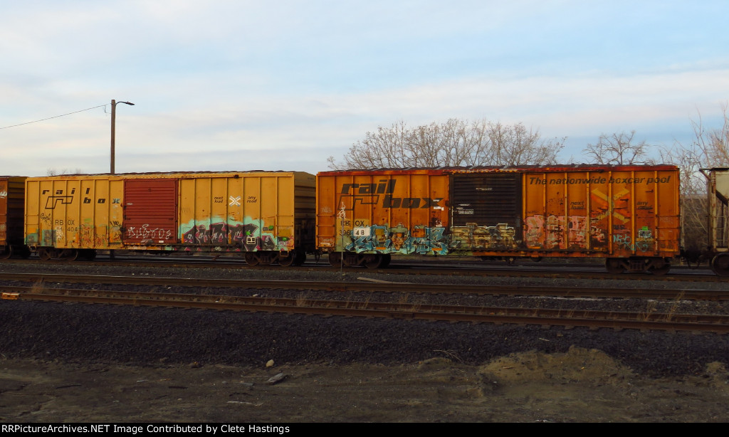 Two TTX boxcars, in different schemes